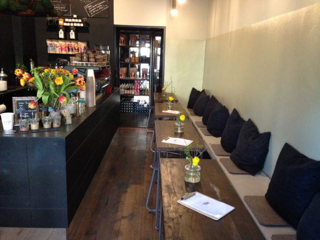Sitzbank und kleine Tische neben dem Tresen im Tilda Café